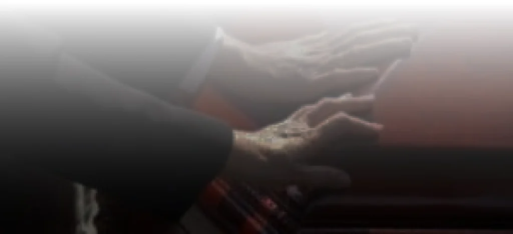 Hands resting on a wooden coffin.