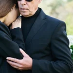 Grieving family members embracing at funeral after wrongful death