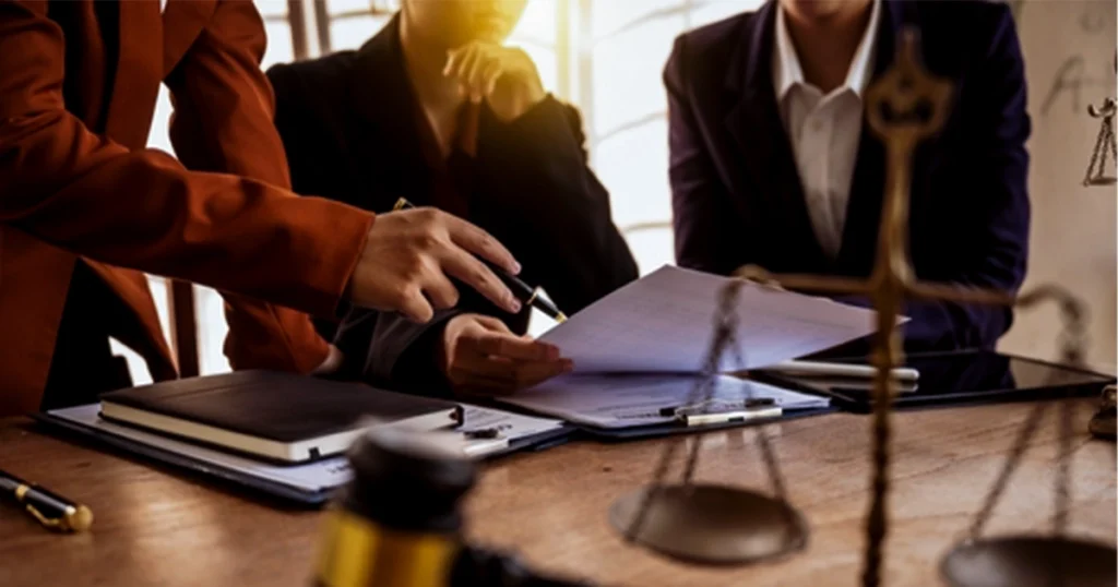 Attorneys discussing paperwork for wrongful death settlement division