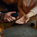 Handing car keys to a friend to avoid driving.